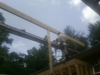 Carpenter setting a ridge beam over a new addition frame — Ice Dam Removal by Roofing Brothers in Powell
