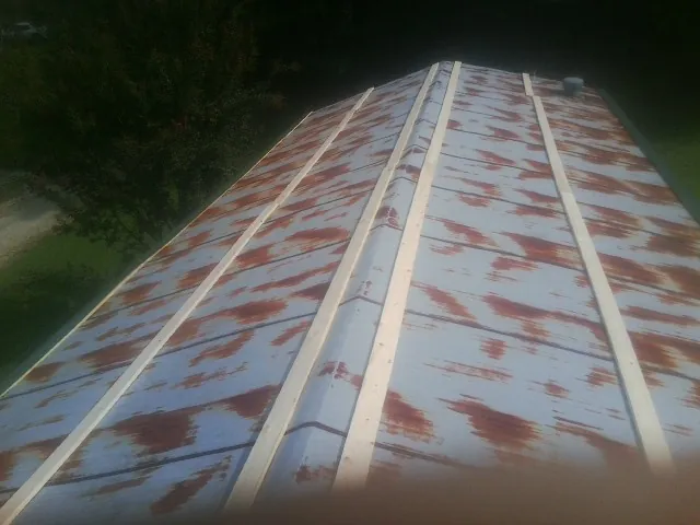 Rusted metal roof panels with new wood purlins before replacement — Storm Damage Roof Repair in Powell by Roofing Brothers