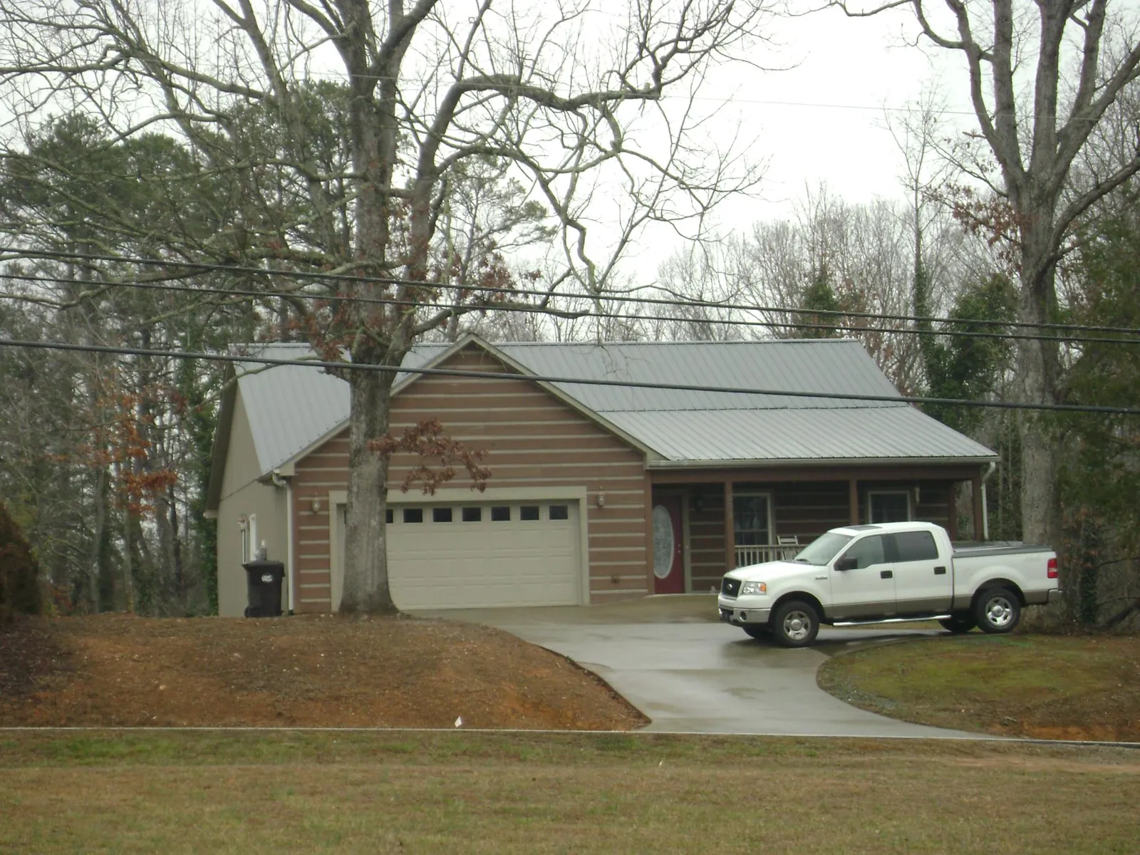 Gray metal roof on a log sided house with an attached two car garage in Powell
